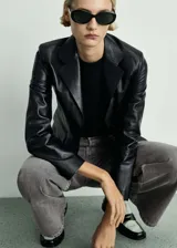 Pantalón de jean gris de corte wideleg, tiro medio, cinco bolsillos y cierre con botones.