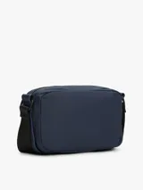 Bandolera Tommy Hilfiger azul marino con correa ajustable de tejido trenzado, cierre de cremallera, bolsillo exterior con cremallera y logo texturizado en la parte delantera.