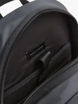 Mochila negra de poliéster con compartimento principal con cierre de doble cremallera, asa superior, correas ajustables y acolchadas, panel de malla acolchado en la parte trasera, funda de portátil incorporada, bolsillo interior con cremallera, bolsillo exterior con cremallera y logo metálico de Tommy Hilfiger en la parte delantera.