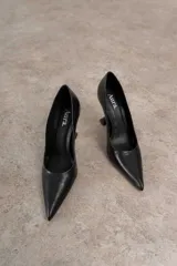 Zapato de cuero color beige con punta fina y taco de forma geométrica.