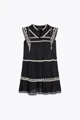 Minivestido negro de algodón con bordados florales blancos en cuello, mangas y ruedo.