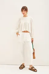 Pantalón cargo negro de corte holgado, con cierre y botones frontales, elástico en la cintura y en los ruedos. Cuenta con bolsillos laterales y en las piernas.