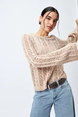 Sweater calado color beige, con escote redondo y mangas acampanadas.