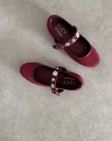 Ballerinas de gamuza color borgoña con correa sobre el empeine adornada con apliques de strass y hebilla metálica.