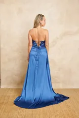 Vestido largo de fiesta color azul eléctrico, strapless, con escote drapeado y falda con abertura lateral.