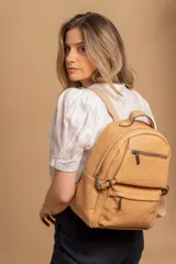 Mochila color marrón de símil cuero con un compartimento principal amplio, bolsillo al frente con cierre, correas ajustables y asa.