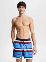Short de baño Tommy Hilfiger con estampado de rayas horizontales en azul, blanco y rojo. Diseño con monograma TH estampado en azul sobre las rayas azules. Cintura elástica con cordón ajustable.