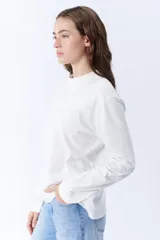Remera manga larga color crudo con cuello redondo.