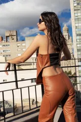 Top negro de cuero con breteles finos y corte recto.