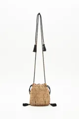 Cartera de noche tipo bolso redondo, confeccionada con lentejuelas y canutillos dorados. Cuenta con cordón de ajuste con borlas negras y correa al tono con apliques de canutillos.