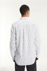 Camisa blanca de manga larga con estampado de piñas azules, cuello abotonado y bolsillo en el pecho con etiqueta roja de la marca Levi's.