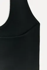 Top negro de cuello halter confeccionado en tejido elástico.