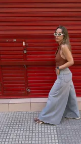 Pantalón de jean celeste de tiro medio con pierna extra ancha y caída fluida, con bolsillos delanteros y traseros, y cierre frontal con cremallera y botón metálico.