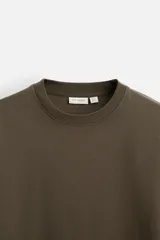 Camiseta color verde militar, de corte cuadrado y tejido de algodón pesado.