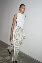 Top blanco de algodón con escote redondo, sin mangas y detalle de logo metálico en el pecho.
