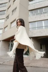 Ruana tejida en lana merino color amarillo pastel, con terminación de flecos.