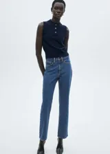 Pantalón de jean azul de corte recto, tiro medio, con cierre de cremallera y botón, cinco bolsillos y detalle en contraste.
