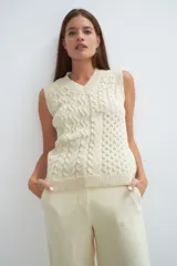 Chaleco tejido marrón con escote en v y sisas amplias. Diseño con diferentes puntos combinados en el frente.