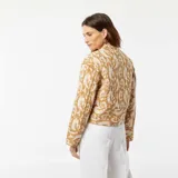 Chaqueta corta acolchada color beige con estampado abstracto en blanco, cuello redondo y cierre frontal con botones.