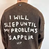 Buzo marrón con efecto gastado, corte oversize y estampa en la espalda con la frase "I will sleep until my problems disappear".