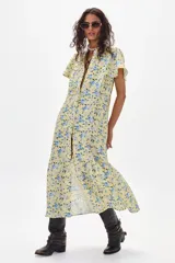 Vestido midi amarillo con estampado floral celeste, de corte recto, con cuello mao y abertura frontal con botones.