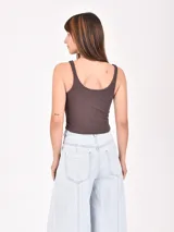 Musculosa corta marrón de morley con breteles finos y estampado de una estrella blanca en el centro.