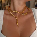 Collar rígido dorado con forma de serpiente enroscada, con detalles de textura simulando escamas y ojos negros.