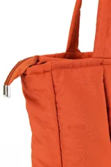 Bolso shopper color naranja con diseño acolchado y cierre superior.