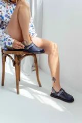 Zuecos azul marino con suela negra y tira trasera estampada en tonos azules.