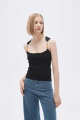 Musculosa negra de punto canale entallada, con cuello recto y tirantes con cuentas.
