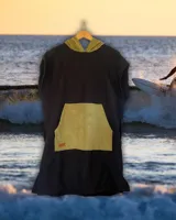 Poncho de toalla negro con capucha y bolsillo canguro color verde oliva. Ideal para usar después de nadar o surfear.