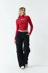 Top blanco de manga larga con cuello alto y abertura en el pecho. Corte ajustado y tejido elastizado.