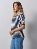Remera de algodón a rayas horizontales rosas y blancas, con cuello redondo y mangas cortas con detalle de aberturas entrelazadas.