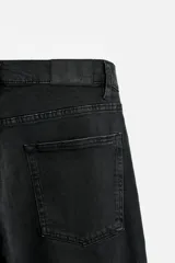 Pantalón de jean azul oscuro, corte slim fit, tiro medio, cinco bolsillos, tejido elástico y efecto lavado.