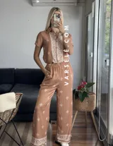 Conjunto de camisa de manga corta con cuello y pantalón largo de corte palazzo, ambos con estampado geométrico en blanco y negro.