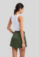 Minifalda negra de jean con bolsillos cargo y cinturón con hebilla metálica.