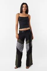 Pantalón de corte recto con cintura media, paneles en negro, gris y verde oliva, y cinturón con hebilla plástica.