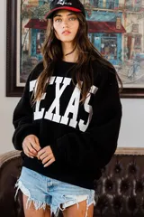 Sweater negro de felpa con la palabra "TEXAS" estampada en blanco en el frente.