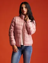Campera puffer reversible Michael Kors color rosa con estampado de logos MK en un lado y liso en el otro. Tiene cierre central metálico, bolsillos delanteros y avíos metálicos con logo. Incluye bolsa autoportante.
