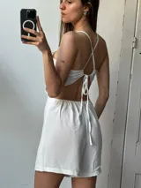 Mono corto blanco con espalda descubierta y tiras finas cruzadas.