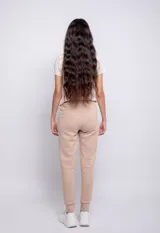 Pantalón de jogging color beige con puños elásticos, bolsillos laterales y cordón ajustable en la cintura.