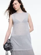 Musculosa sin mangas color gris, tejida en hilado con brillo sutil. De calce relajado y largo por debajo de la cadera, presenta aberturas laterales.