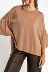 Sweater color cobre brillante, de tejido de punto con lurex, corte oversize, cuello redondo y mangas 3/4 con volados.