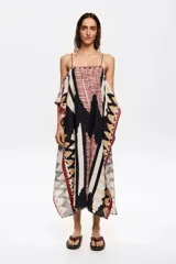 Vestido largo con estampado geométrico en tonos blanco, negro, rojo y marrón. Tiene tirantes finos y corte holgado.