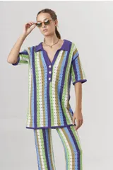 Sweater de tejido crochet a rayas verticales en tonos azul, verde, marrón y blanco, con cuello polo y cierre de botones.