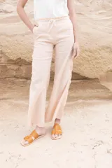 Pantalón de lino color beige, de corte recto, con volados laterales y en la pretina.
