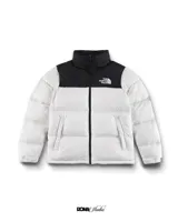 Campera puffer blanca con cuello alto y parte superior en negro. Logo de The North Face bordado en el pecho.