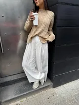 Pantalón sastrero negro de corte palazzo, con botón, pasacinto y pretina trasera con elástico.