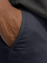 Short chino azul marino de lino y algodón, corte relajado, cintura media con elástico y cordón ajustable, bolsillos frontales y traseros.