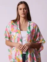 Kimono tejido con estampado floral multicolor y terminación de ruedo con borlas verdes.